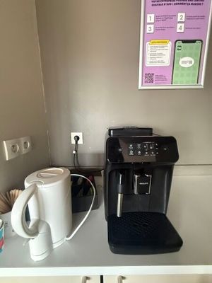 a coffee maker and a cup on a counter
