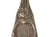 an old spoon with a metal handle on a white surface