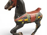 a toy horse that is standing up on a white surface