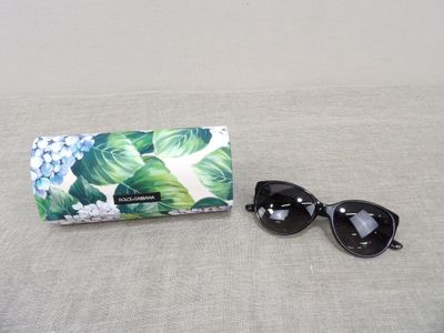 a pair of sunglasses and a case sitting on a bed