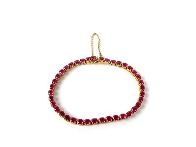 un gros plan d'un bracelet en perles rouges sur fond blanc