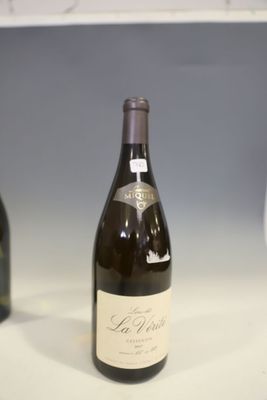une bouteille de vin posée sur un comptoir à côté d'un verre de vin