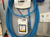 a blue hose attached to the wall of a gas station