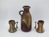 three vases and two cups sitting on a table