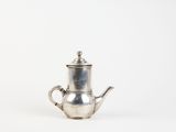 an old silver teapot with a handle on a white background
