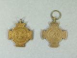 two gold medals with a cross and a medallion on them