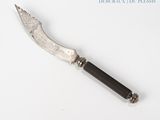a knife that is laying on a white surface
