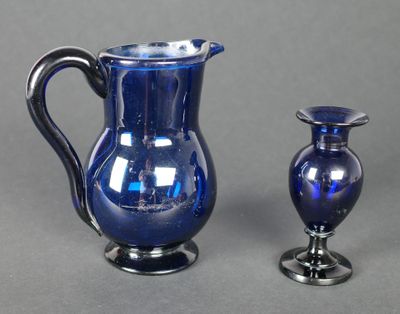 deux vases en verre bleu posés l'un à côté de l'autre sur une table