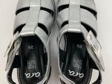 a close up of a pair of silver sandals on a white surface