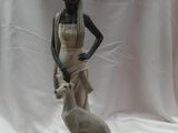 statue d'une femme accompagnée d'un chien, posée sur un socle, sur fond blanc