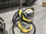 deux aspirateurs posés par terre dans le garage