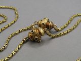 a gold necklace with a chain that has two bells on it