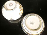 two white bowls with blue and gold designs on them