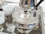 a silver tray with cups and a teapot on it