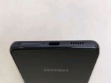 the back of a black cell phone sitting on top of a white table