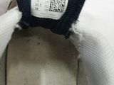 someone is holding a pair of shoes with a label on them