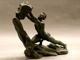 une statue en bronze d'un homme assis sur un rocher
