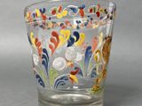 a glass cup that has a colorful design on it