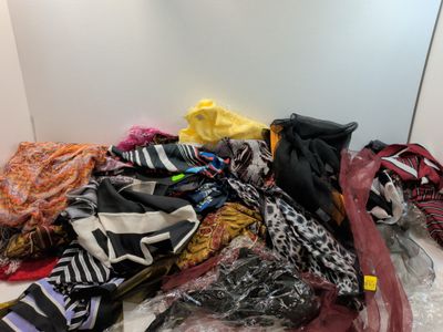 un tas de vêtements par terre, à côté d'un miroir