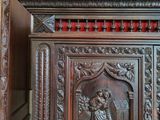 a wooden cabinet with carvings on it in a room