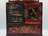 un meuble rouge et noir sur lequel est posée une horloge