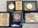 four different types of silver coins in plastic cases on a table