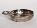 an antique silver plate with a handle on a white surface