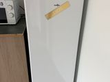 un réfrigérateur blanc sur lequel est collé un autocollant, à côté d'un micro-ondes