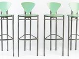 three green bar stools sitting next to each other on a white surface