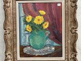 un tableau représentant des tournesols dans un vase vert posé sur une table