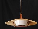 a wooden light fixture hanging from a ceiling with a black background