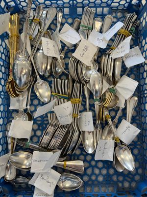 un panier rempli de cuillères en argent et de cuillères sur lesquelles sont inscrites des notes