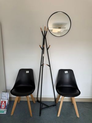 deux chaises noires et un miroir dans une pièce