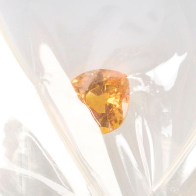 a yellow diamond in a clear bag on a table