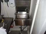 a stainless steel sink in the corner of a room