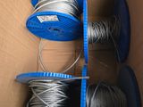 deux bobines de fil métallique dans une boîte en carton munie d'une poignée bleue