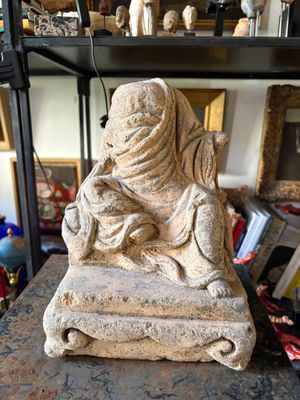 a statue of a woman sitting on top of a table