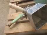 a metal microwave sitting on a pallet with a green handle