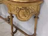 a gold console table with a mirror on top of it