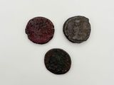 three roman coins are shown on a white surface
