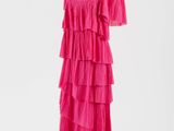 une robe rose posée sur un pied de mannequin, sur fond blanc