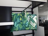 un sac vert et blanc suspendu à une étagère dans un bureau