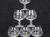 six wine glasses stacked on top of each other on a black background