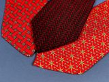 three different colored ties on a blue surface with a blue background
