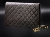 a black purse with a chain on a black background