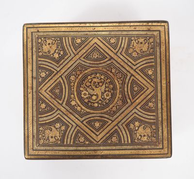 an old box with gold and black designs on a white background
