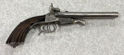 gros plan d'un pistolet sur une table à fond blanc