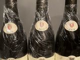 three bottles of wine wrapped in plastic sitting on a table