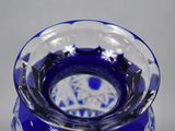 a blue glass vase with a flower design on it