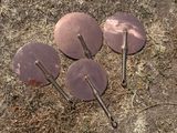 plusieurs parasols métalliques posés au milieu d'un champ recouvert d'herbe sèche